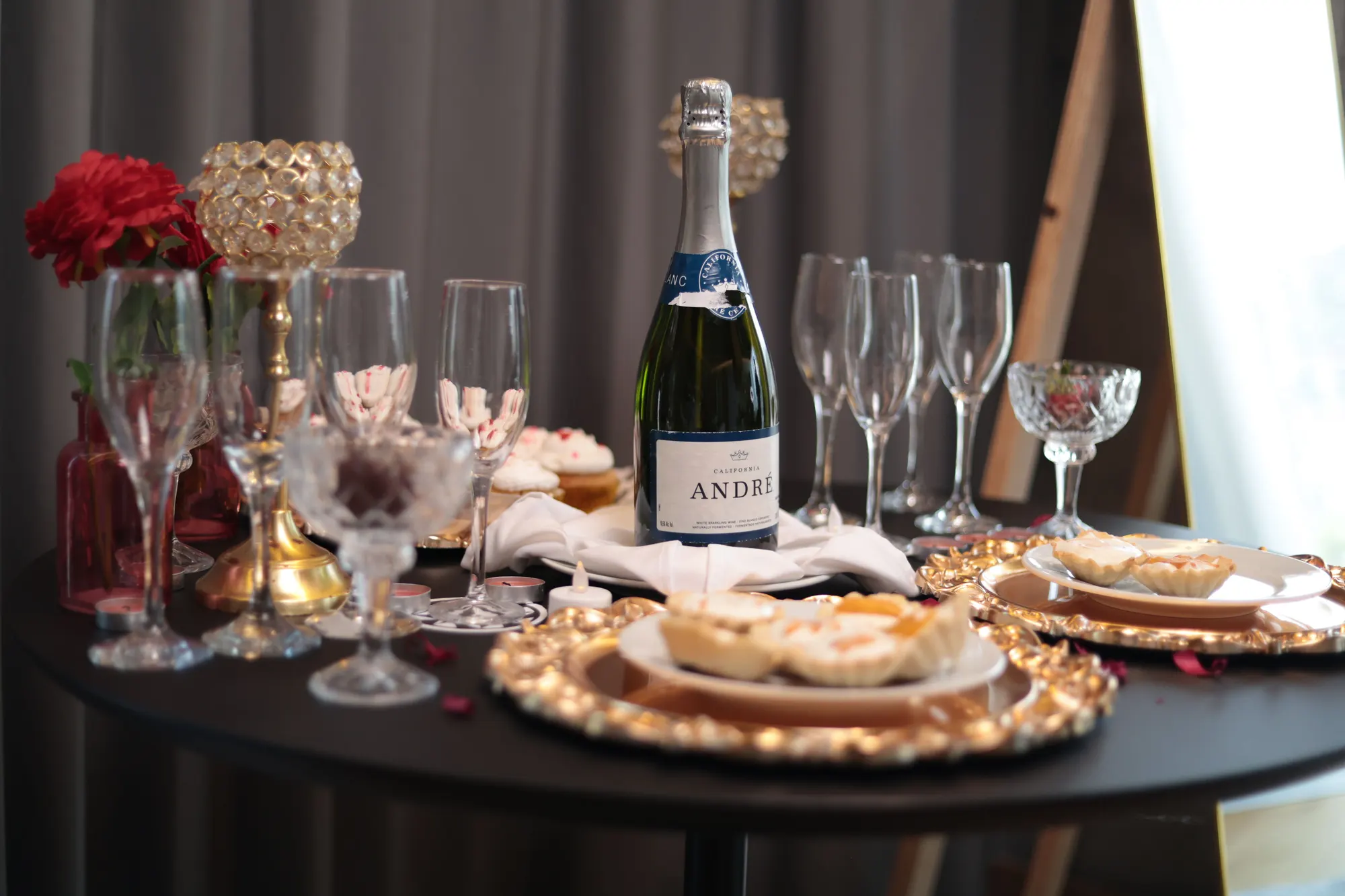 Mesa de boda con champaña, copas y postres