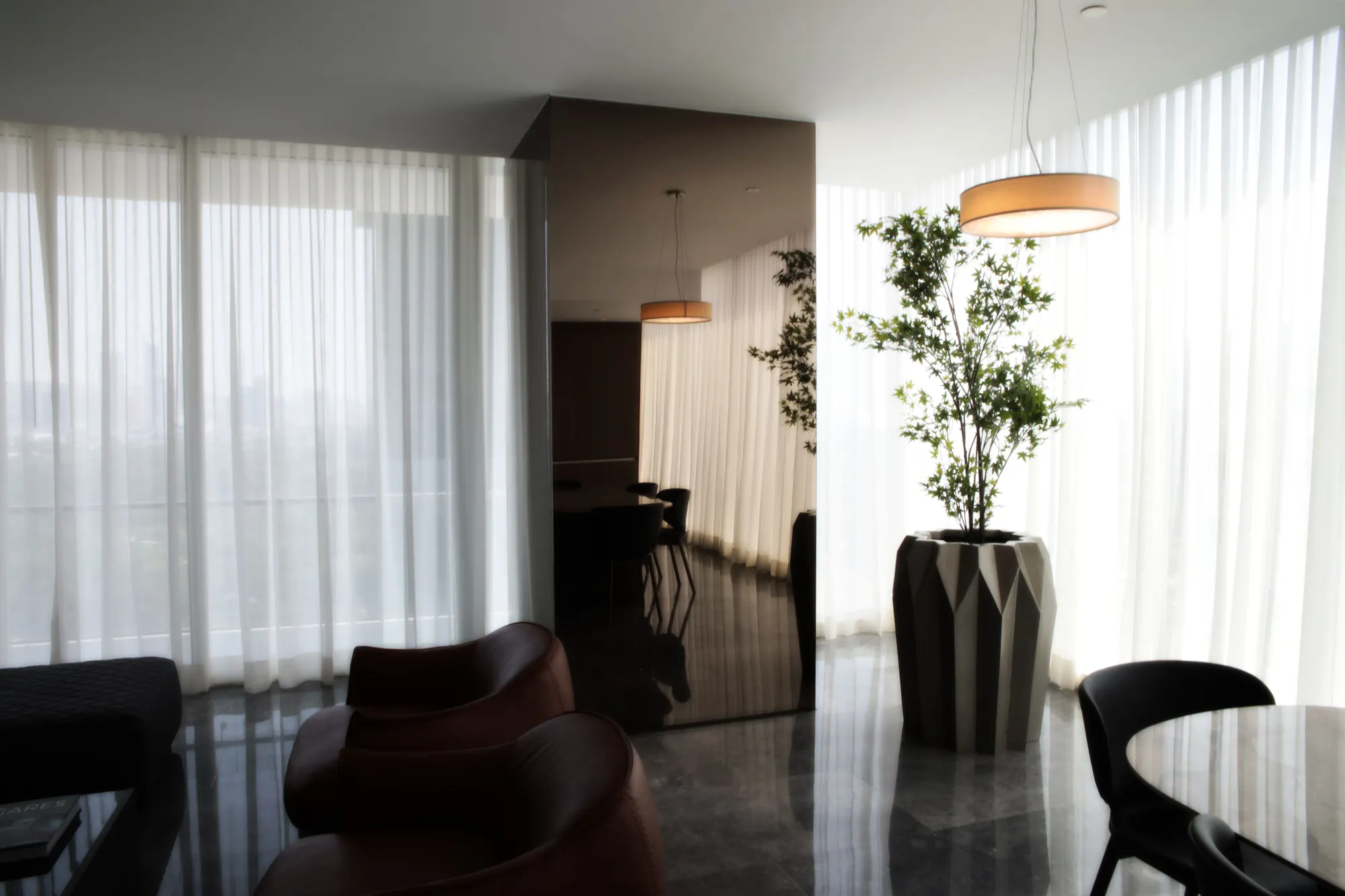 Interior de una sala moderna con ventanales y cortinas