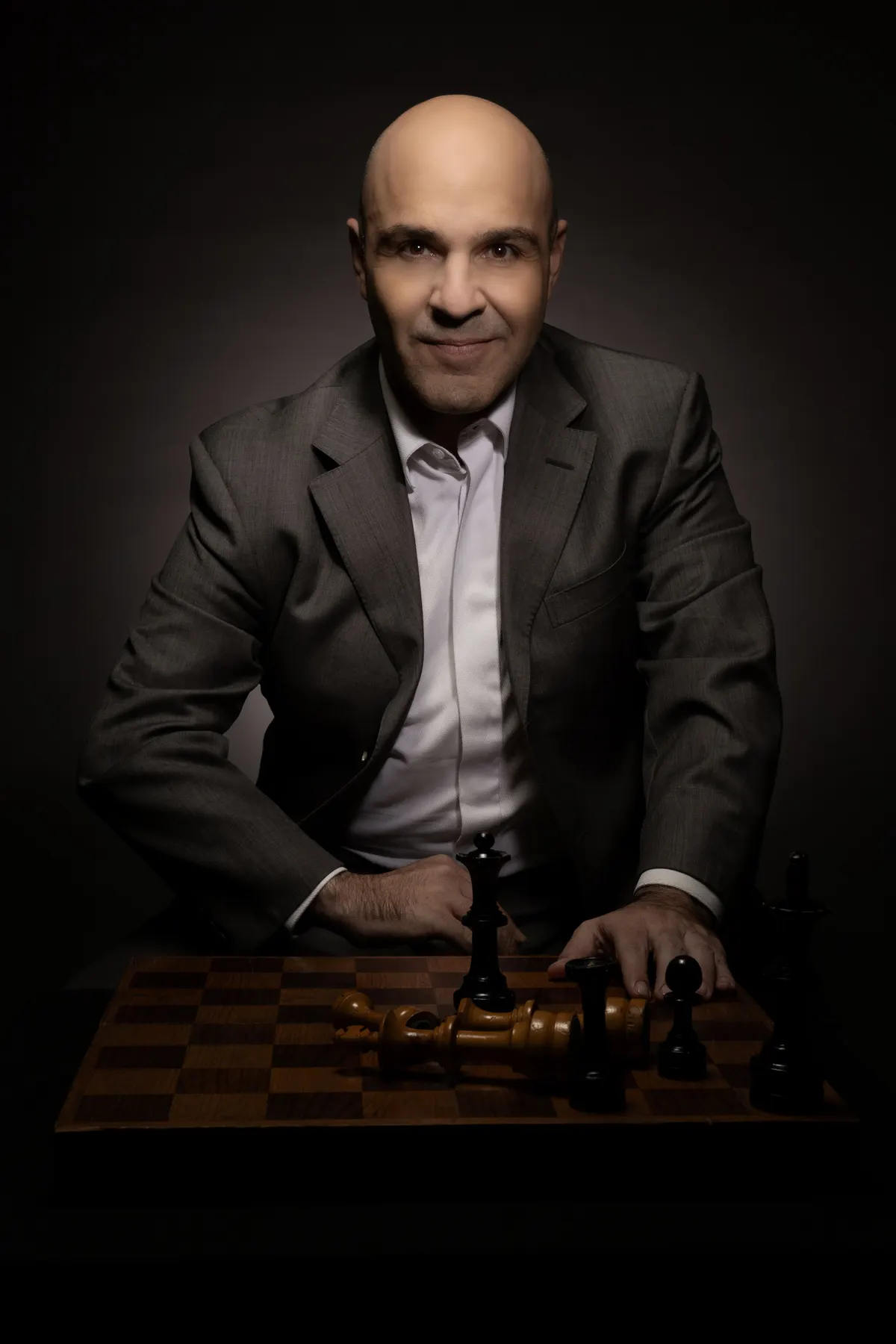 Retrato de un hombre de traje con un tablero de ajedrez
