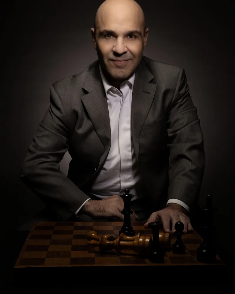 Retrato de un hombre de traje con un tablero de ajedrez