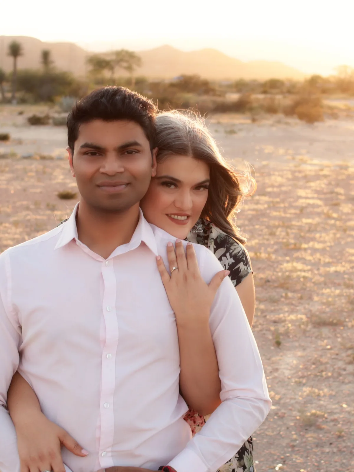 Pareja abrazada en el desierto al atardecer
